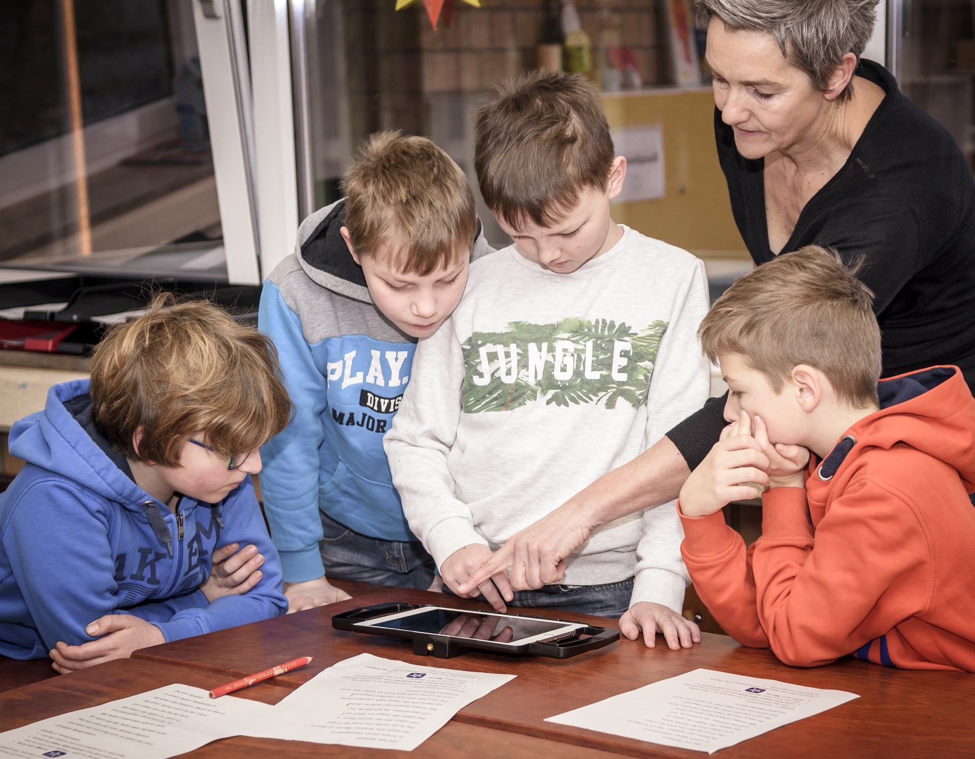 Lehrerin erklärt Schülerinnen etwas am Tablet, das vor ihnen auf dem tisch liegt. | LWL-Medienzentrum, Partick Schulte Lehrerin erklärt Schülerinnen etwas am Tablet, das vor ihnen auf dem tisch liegt. | LWL-Medienzentrum, Partick Schulte