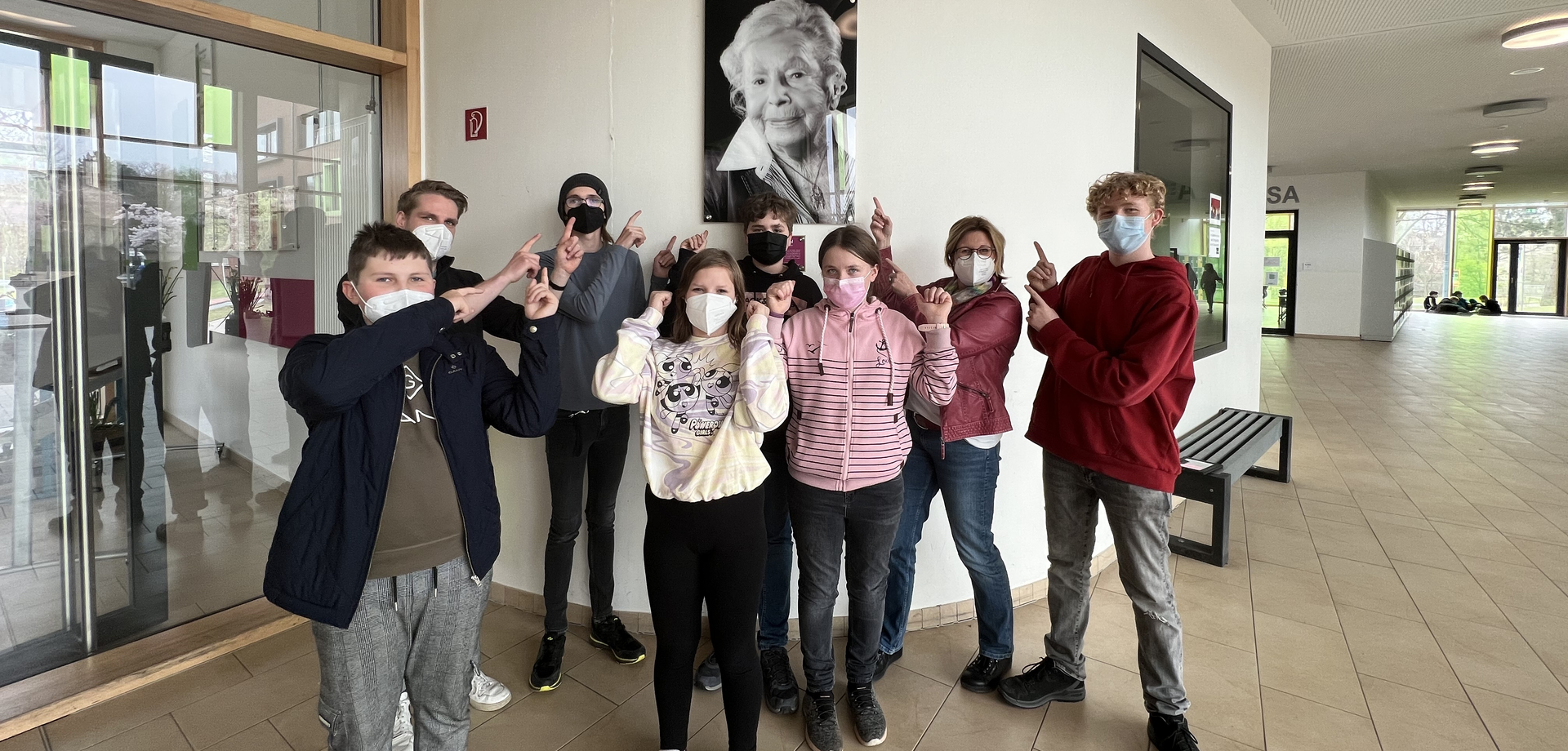 Die Schüler:innen der Projektgruppe in Werne vor dem Porträt von Marga Spiegel.