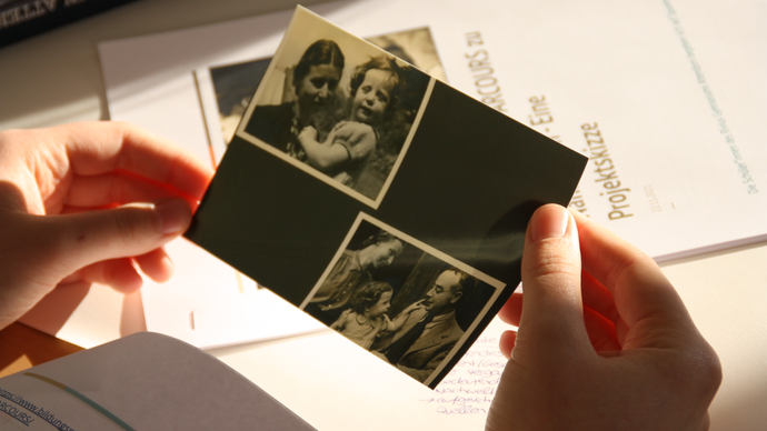 Hände halten eine schwarz-weiß Fotografie.